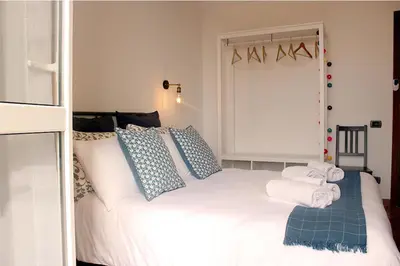 a bedroom with a large white bed with blue pillows at Vinylogy Apartment 5to Piano in Rome