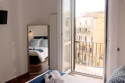 a bedroom with a mirror and a bed and a balcony at Vinylogy Apartment 5to Piano in Rome