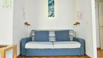 a blue couch sitting in a living room at Casa Tua a Monti in Rome