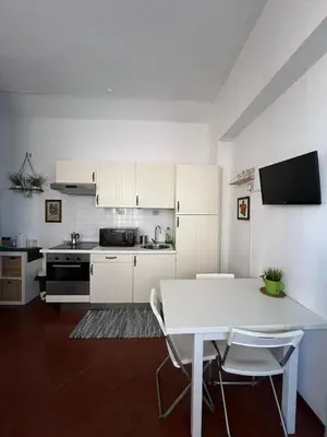a kitchen with white cabinets and a table and chairs at Apartment - Laterano 85 in Rome