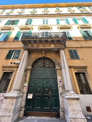 a building with a green door in front of it at Apartment - Laterano 85 in Rome