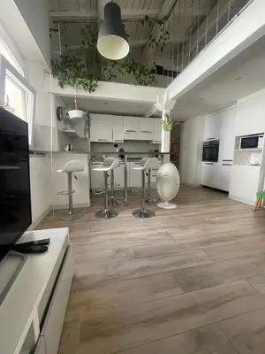 a kitchen with stools and a kitchen with white cabinets at Gens Julia in Rome