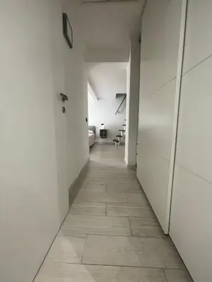 an empty hallway with white walls and a tile floor at Gens Julia in Rome