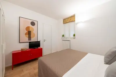 a bedroom with a bed and a tv on a red cabinet at SuityRHome San Pietro 99 in Rome