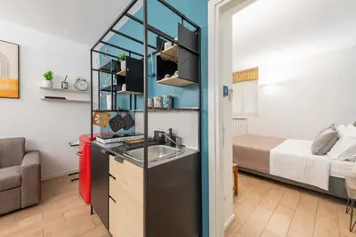 a kitchen with a sink in a room with a bed at SuityRHome San Pietro 99 in Rome