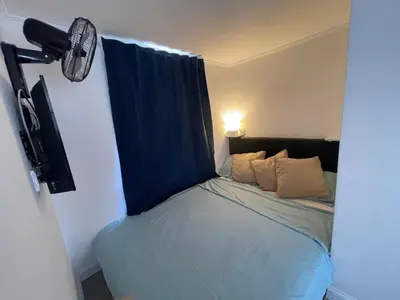 a small bedroom with a bed with a blue curtain at Little Aventino BnB in Rome