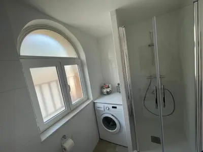 a bathroom with a washing machine and a window at Little Aventino BnB in Rome