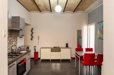 a kitchen with a table and red chairs at GuestHost - San Lorenzo Welcoming Apartment in Rome