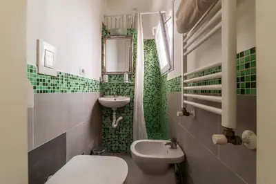 a bathroom with a sink and a toilet and a mirror at GuestHost - San Lorenzo Welcoming Apartment in Rome