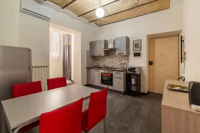 a kitchen with a table and red chairs at GuestHost - San Lorenzo Welcoming Apartment in Rome