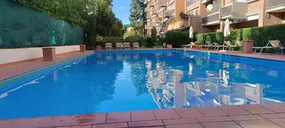 a swimming pool with blue water in a building at Studio Suite Aurelia Antica in Rome