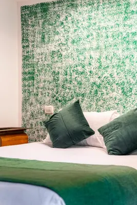 a bed with green and white pillows in a bedroom at Studio Suite Aurelia Antica in Rome
