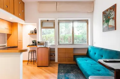 a living room with a blue couch in a kitchen at Studio Suite Aurelia Antica in Rome