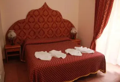 a hotel room with a red bed with towels on it at Alloggio Turistico in Rome