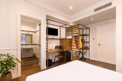 a room with a bed and a sink and a television at Alla Corte Guest House by Hili in Rome