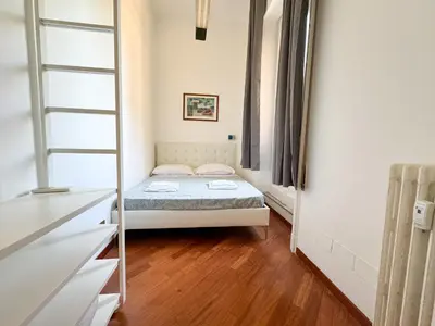 a small bedroom with a bed and a mirror at Montezebio Boutique Apartment in Rome