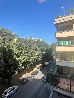 a street with cars parked on the road next to a building at Montezebio Boutique Apartment in Rome