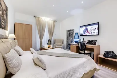 a hotel room with two beds and a tv at Relais Colonna in Rome