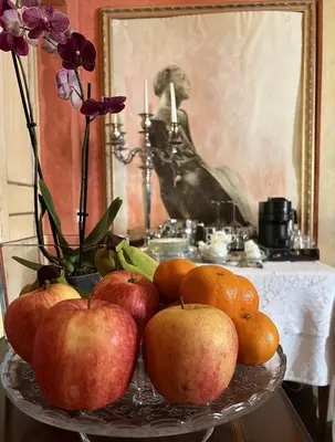 a bowl of apples and oranges on a table with a painting at Suite Palazzo Bonaventura in Rome