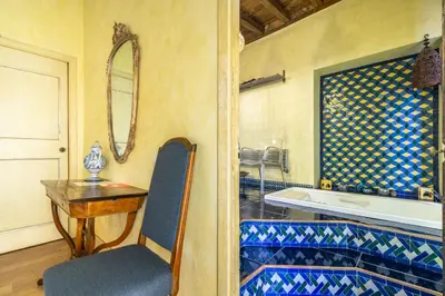 a bathroom with a tub and a table and a chair at Suite Palazzo Bonaventura in Rome