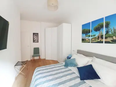 a white bedroom with a bed and a chair at Have a nice stay in Rome in Rome