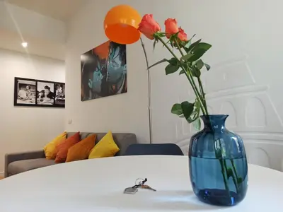 a blue vase with flowers sitting on a table at Have a nice stay in Rome in Rome