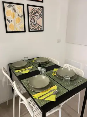 a dining room table with chairs and a black table with plates at Domus76 Casa Vacanze in Rome