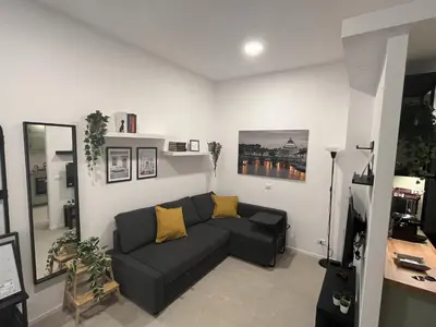 a living room with a black couch and yellow pillows at Domus76 Casa Vacanze in Rome