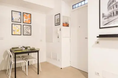 a dining room with a table and white walls at Domus76 Casa Vacanze in Rome