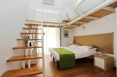 a bedroom with a bed with a green blanket on it at Vatican Holiday Home in Rome