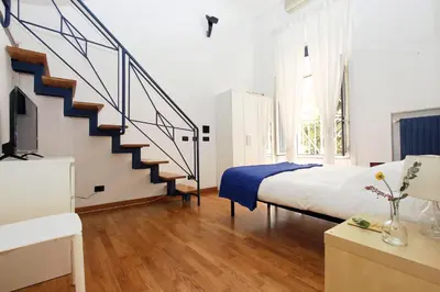 a bedroom with a bed and a spiral staircase at Vatican Holiday Home in Rome