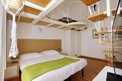 a bedroom with a bed with a green blanket at Vatican Holiday Home in Rome