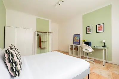 a bedroom with a white bed and a desk at Domiziano Boutique Apartment in Rome