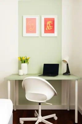 a desk with a laptop and a white chair at Domiziano Boutique Apartment in Rome