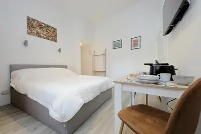a bedroom with a bed and a table with a microwave at suity I cozy barberini studio in Rome