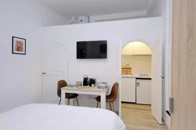 a bedroom with a bed and a table and a kitchen at suity I cozy barberini studio in Rome