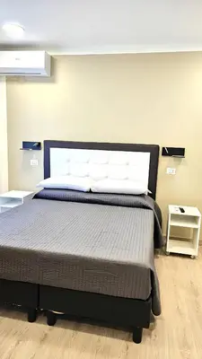 a bedroom with a large bed with aokedokedokedoked at Convenient Booking B&B in Rome