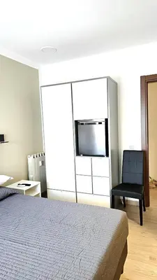 a bedroom with a bed and a black chair at Convenient Booking B&B in Rome