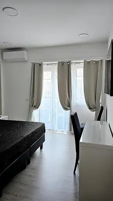 a bedroom with a bed and a desk and window at Convenient Booking B&B in Rome