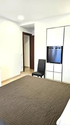 a bedroom with a bed and a chair and a flat screen tv at Convenient Booking B&B in Rome