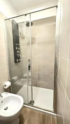 a bathroom with a shower and a toilet and a sink at Convenient Booking B&B in Rome