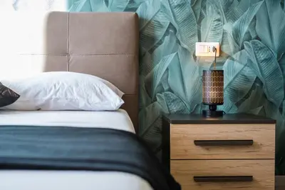a bedroom with a bed and a night stand with a lamp at Roma Design Rooms San Giovanni Colosseo Area in Rome