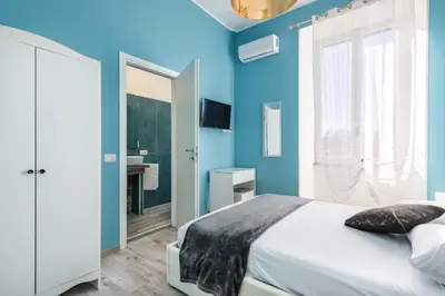 a blue bedroom with a bed and a bathroom at Roma Design Rooms San Giovanni Colosseo Area in Rome
