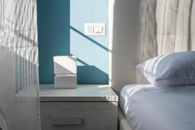 a bedroom with a bed and a night stand with a lightswitch at Roma Design Rooms San Giovanni Colosseo Area in Rome