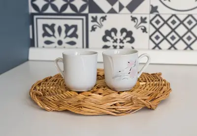 two white cups sitting on a basket on a counter at Roma Design Rooms San Giovanni Colosseo Area in Rome