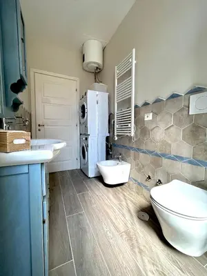 a bathroom with two sinks and a toilet and a refrigerator at Casa Minerva a Testaccio in Rome