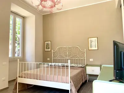a bedroom with a bed and a chandelier at Casa Minerva a Testaccio in Rome
