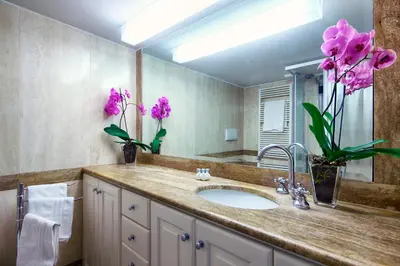 a bathroom with a sink and a mirror and flowers at White Style Gambero in Rome