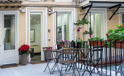 a patio with chairs and flowers on a balcony at White Style Gambero in Rome