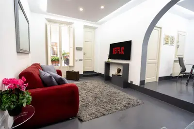 a living room with a red couch and a tv at White Style Gambero in Rome